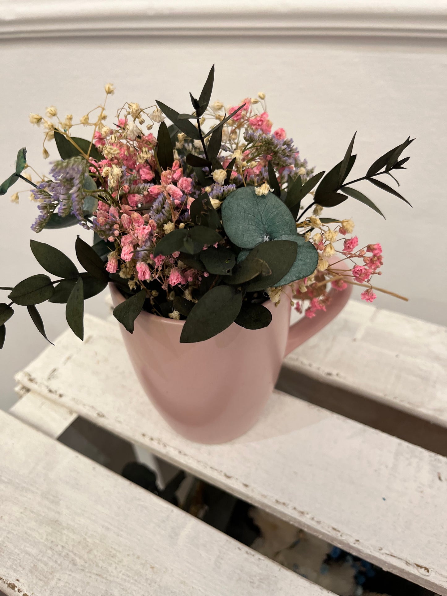Taza rosa claro con flores preservadas